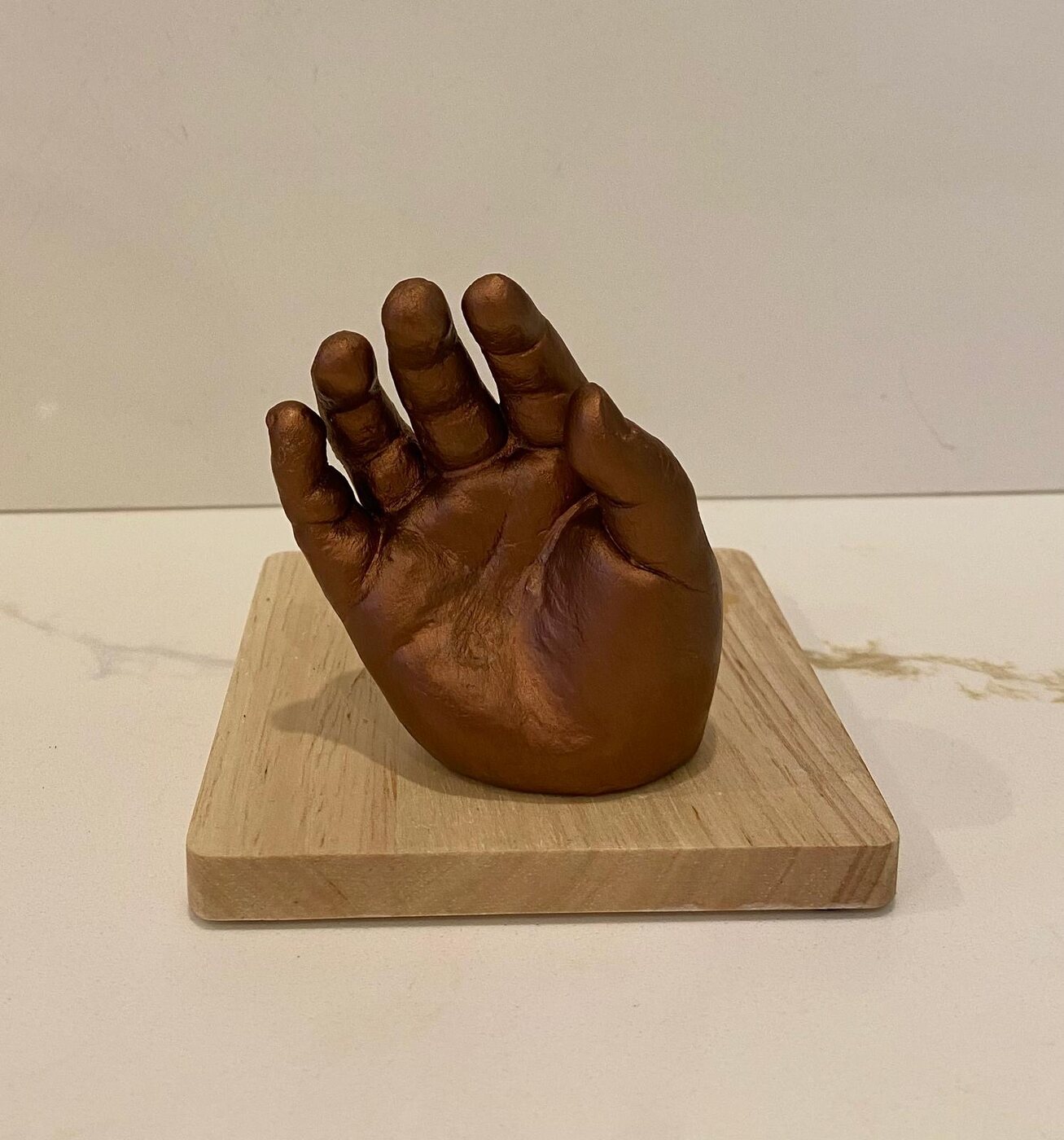 Bronze-finished hand cast mounted on a hardwood block